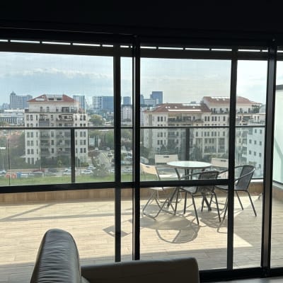 מרפסת עם דלתות זכוכית ונוף לעיר