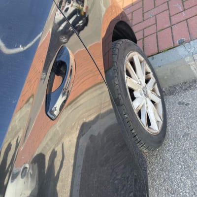 צד רכב עם גלגל ודלת, השתקפות על הצבע.