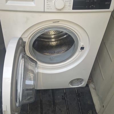 מכונת כביסה פתוחה עם דלת פתוחה ותוף גלוי