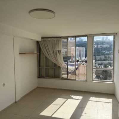 חדר ריק עם חלונות גדולים ונוף עירוני