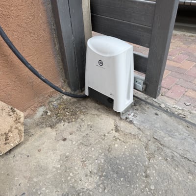 מנוע חשמלי לשער חניה ליד קיר בטון