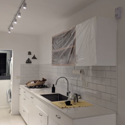 מטבח משופץ עם ארונות לבנים וכיור חדש
