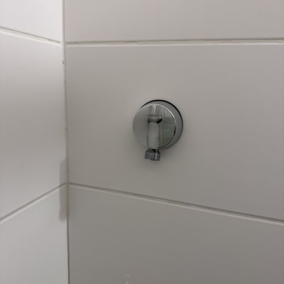 חיבור צינור מים על קיר אריחים לבנים