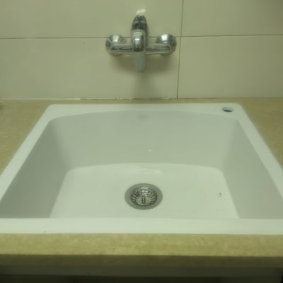 כיור משיש עם ברז מתכת על קיר אריחים