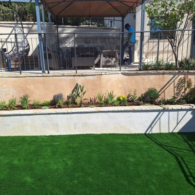 ערוגת פרחים מטופחת עם דשא סינתטי ירוק