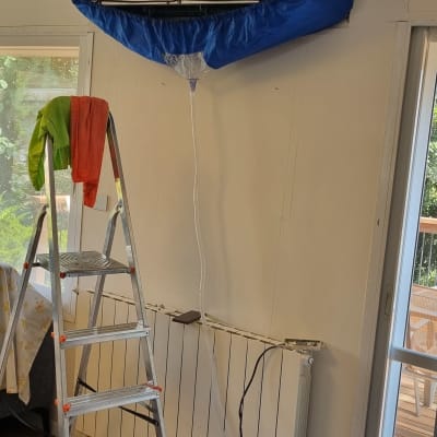 מזגן מפורק עם כיסוי כחול על הקיר