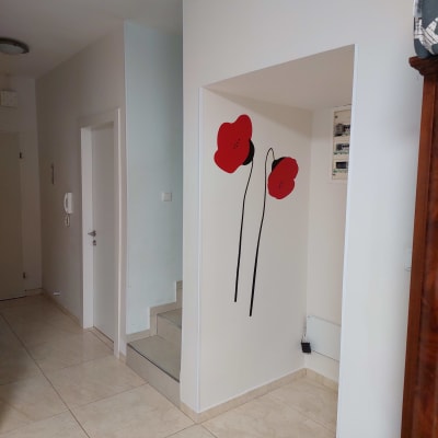 קיר עם ציור פרחים אדומים ומדרגות קטנות