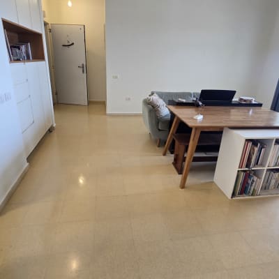 חדר מגורים עם שולחן, ספה ומדפים