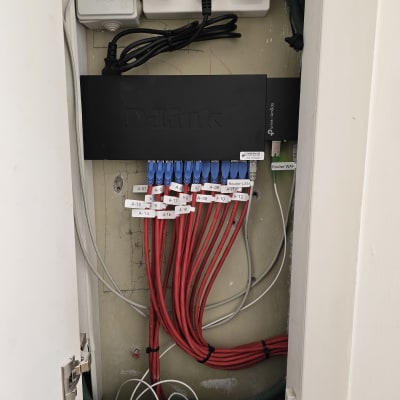 ארון תקשורת עם כבלים אדומים ומתג D-Link