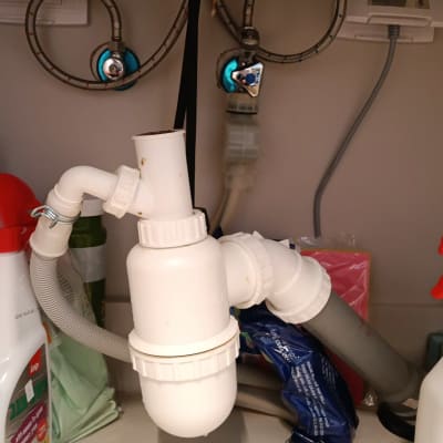 צנרת מתחת לכיור עם חיבורים וכלים
