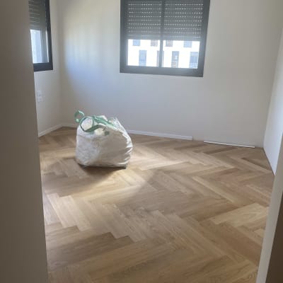 רצפת פרקט עץ בהתקנה בחדר ריק עם חלון