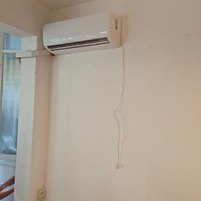 מזגן מותקן על קיר עם כבל חשמל תלוי