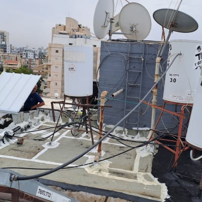 דודי שמש וצלחות לוויין על גג בניין