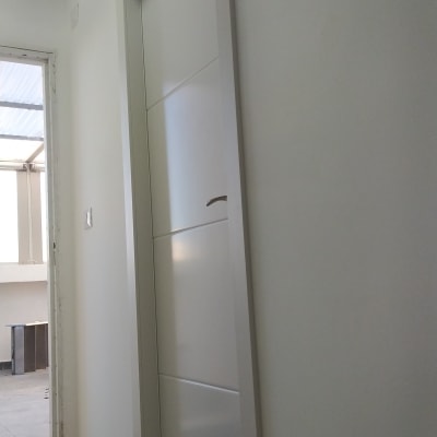 דלת לבנה עם ידית מתכת בחדר מואר