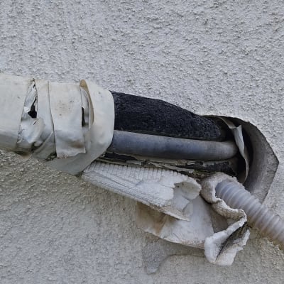 צינור עם נזילה עטוף בסרט דביק על קיר