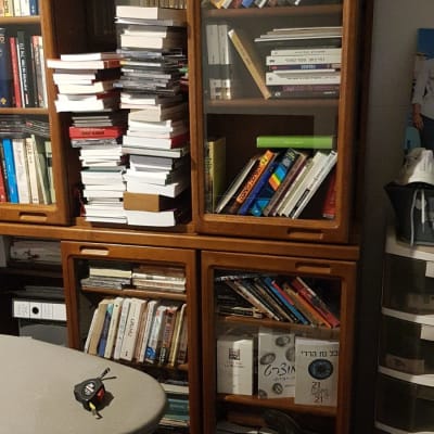 מדף ספרים עם ספרים רבים, כיסא ושולחן קטן