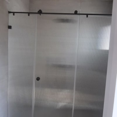 מקלחון עם דלתות זכוכית מחוסמת בחדר אמבטיה