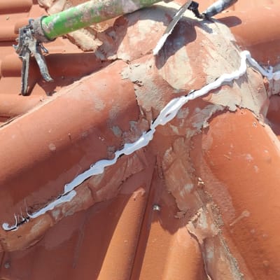 כלי איטום ירוק על גג רעפים עם חומר איטום לבן