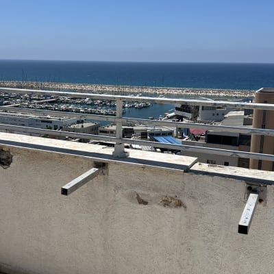 מרפסת עם נוף לים ומעקה מתכת