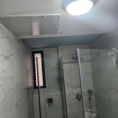 חדר אמבטיה עם מקלחון ותאורה עליונה