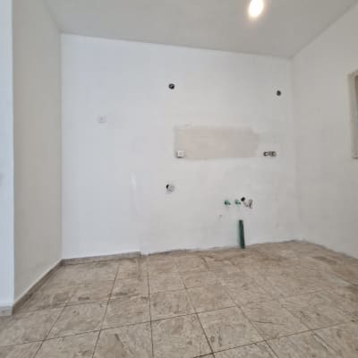 חדר ריק עם קיר לבן ורצפת אריחים