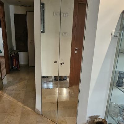 מראה גדולה על קיר עם השתקפות דלת