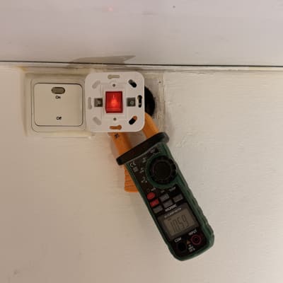 מד מתח מחובר לשקע חשמלי בקיר