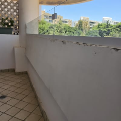 מעקה זכוכית במרפסת עם נוף עירוני
