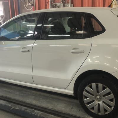 רכב לבן על מסלול במוסך לתיקון פחחות