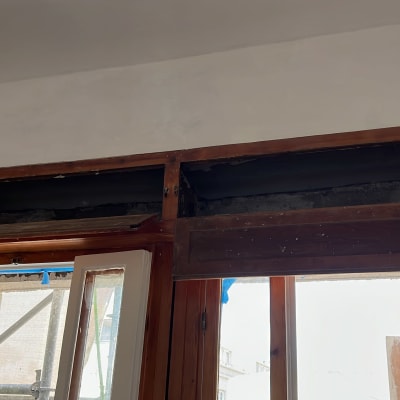 חלון עץ פתוח עם מסגרת עליונה חשופה