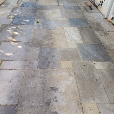 רצפה מלוכלכת עם סימני רגליים ומטאטא בפינה