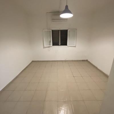 חדר ריק עם קירות לבנים ורצפת אריחים