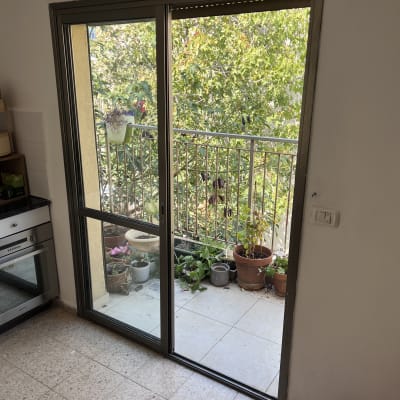 תריסים על חלון זכוכית עם מסגרת מתכת