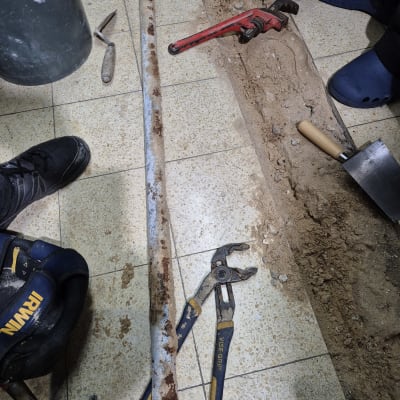 כלי עבודה של אינסטלטור, כולל צינור חלוד ומפתח צינורות