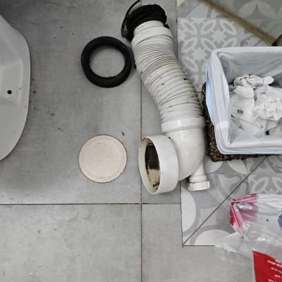 צינור פלסטיק לבן עם מחברים על רצפה אפורה