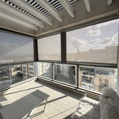 מרפסת עם סוככים נגללים ונוף עירוני