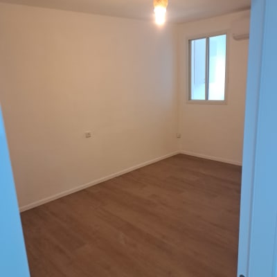 חדר ריק עם רצפת עץ ותאורה עליונה