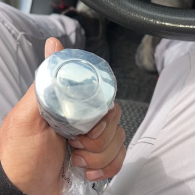 יד מחזיקה חפץ עגול בתוך רכב