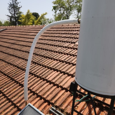 צינור מחובר לדוד שמש על גג רעפים