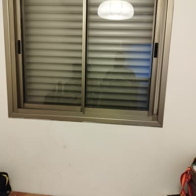 תריסים סגורים בחלון עם מסגרת מתכת