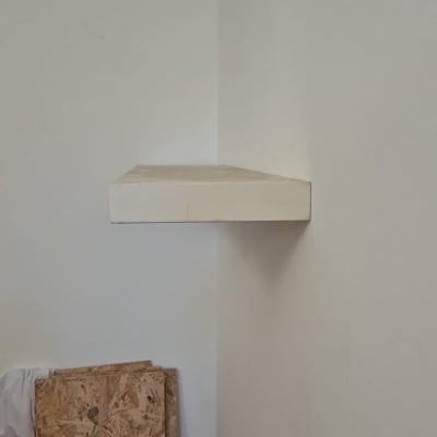 מדף עץ מותקן על קיר לבן