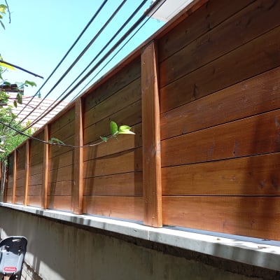 גדר עץ חומה עם קורות אופקיות ועמודים אנכיים