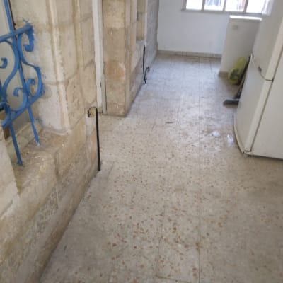 רצפה מלוכלכת עם מטאטא ופח אשפה בפינה