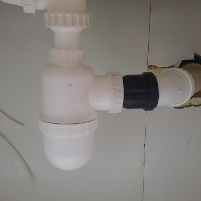 צנרת פלסטיק לבנה עם מחברים מתחת לכיור