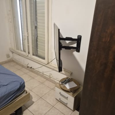 התקנת טלוויזיה על זרוע מפרקית לקיר בחדר שינה