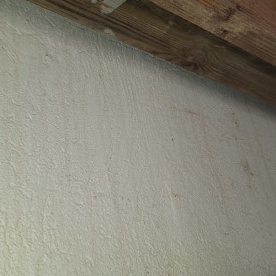 כבל חשמל לבן על קיר עם קורה מעץ