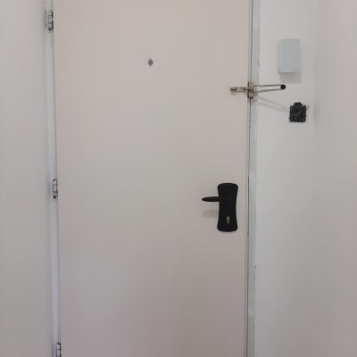 דלת לבנה עם ידית ומנעול שחורים