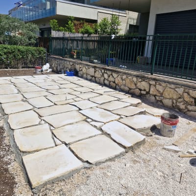 אבנים מרוצפות בגינה עם דליים וכלי עבודה