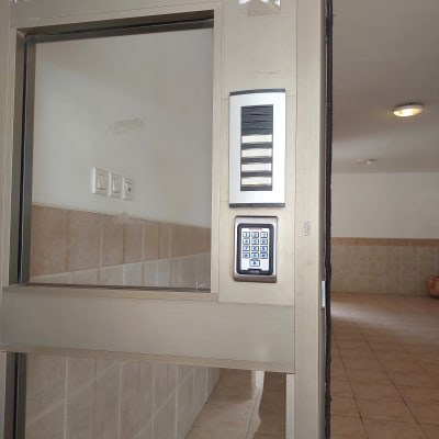 אינטרקום עם לוח מקשים על קיר ליד דלת