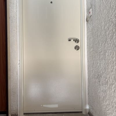 דלת לבנה עם ידית כסופה וקיר לבן